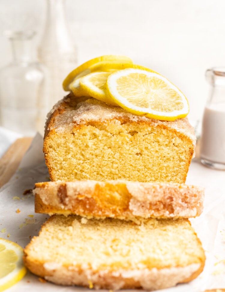 End-view of a gluten free lemon drizzle cake with two slices of cake cut off to show top of cake.