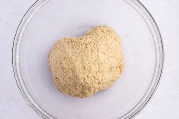 Kneaded ball of seitan dough for seitan fried "chicken" in a large glass mixing bowl.