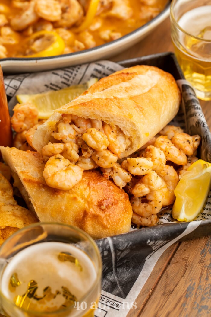 BBQ shrimp po-boys arranged on a pan with delicious buttery shrimp surrounding them.