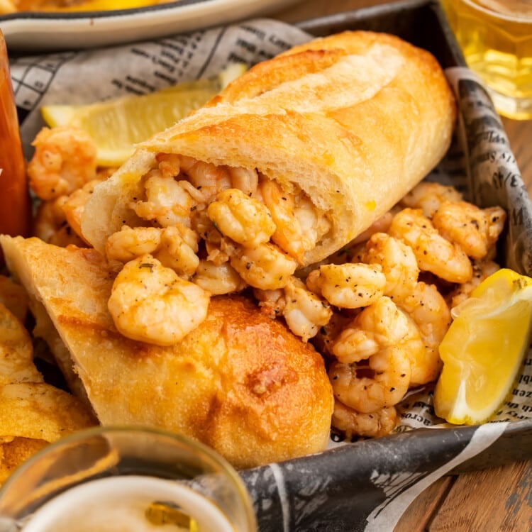 BBQ shrimp po-boys arranged on a pan with delicious buttery shrimp surrounding them.