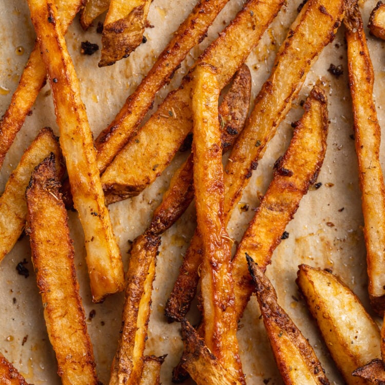 Close-up view of cajun fries on a baking sheet lined with parchment paper.