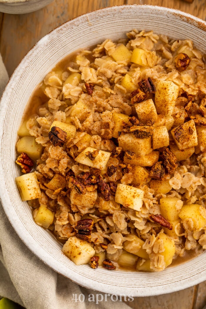 Close-up view of a bowl of apple cinnamon oatmeal, placed with the right half of the bowl cut out of the frame.