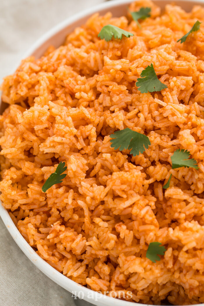 Overhead, close-up view of Instant Pot Mexican rice garnished with chopped fresh cilantro in a large white bowl.