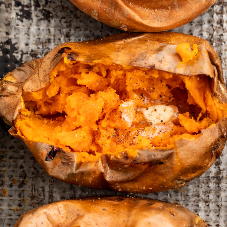 Overhead view of a vertical row of cut-open sweet potatoes on a sheet of foil.