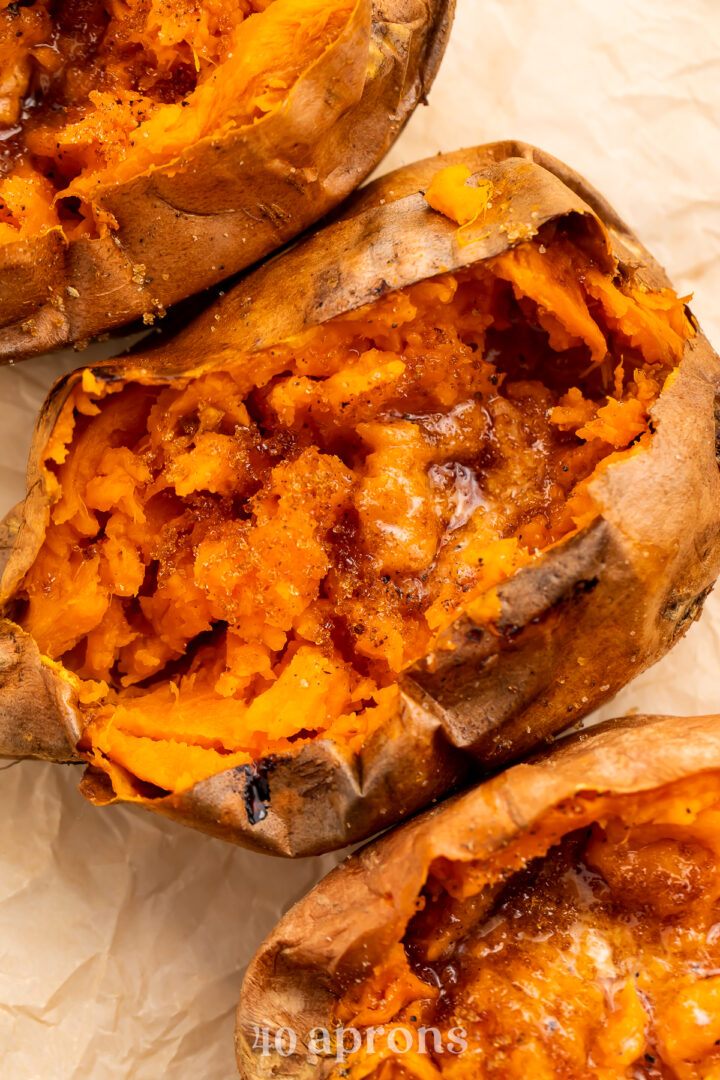 Overhead view of a row of cut-open sweet potatoes angling from the top left corner of the image to the bottom right corner.