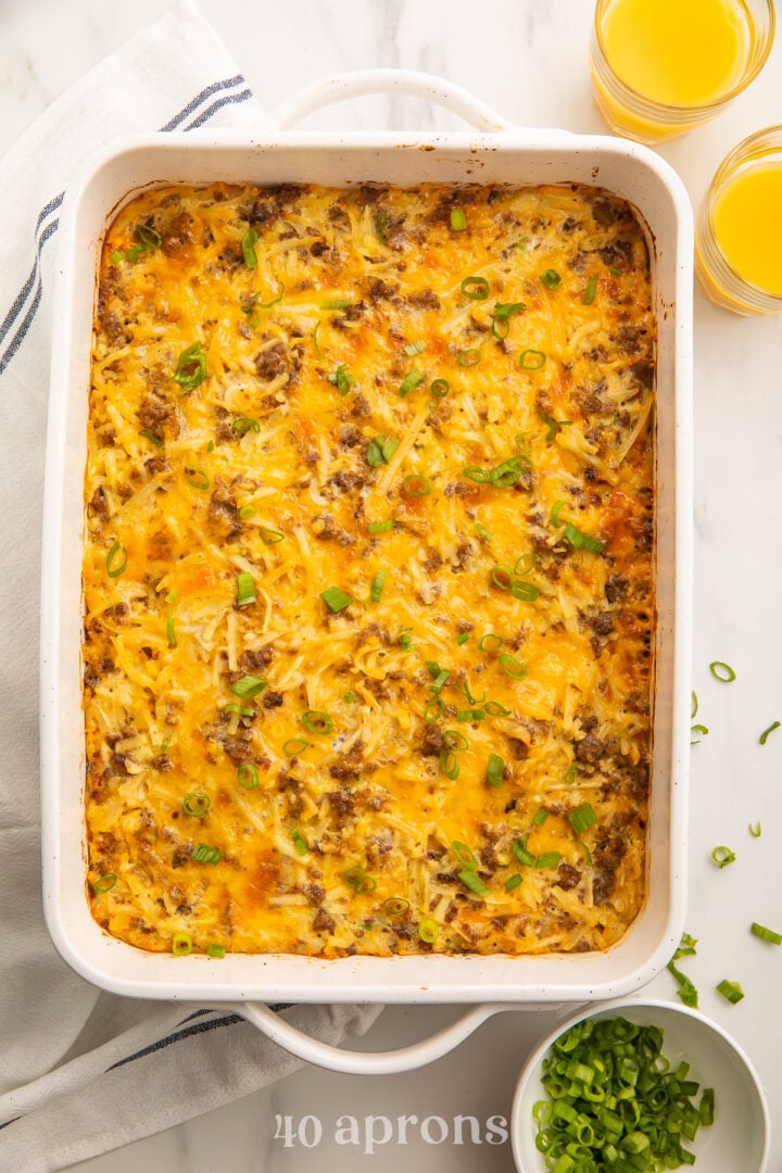 Overhead view of a rectangular casserole dish containing a fully baked gluten free breakfast casserole on a white table.