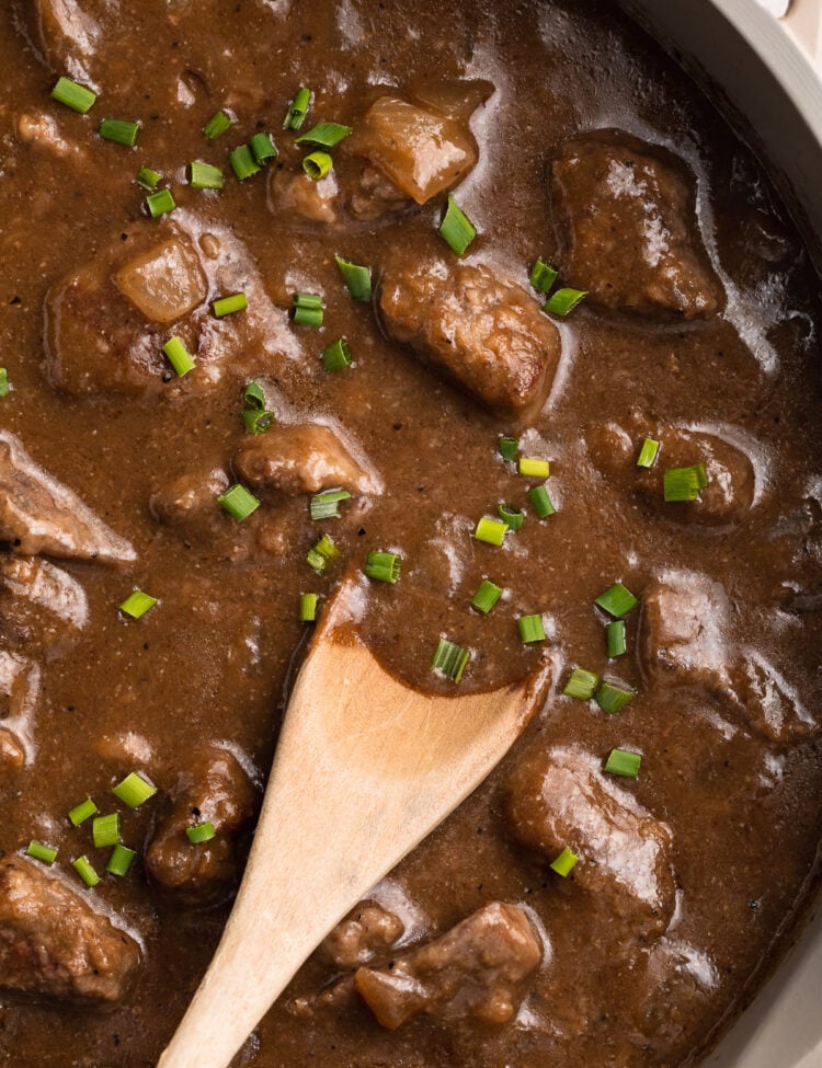 Overhead view of a large skillet holding cook beef tips and rich dark gravy.