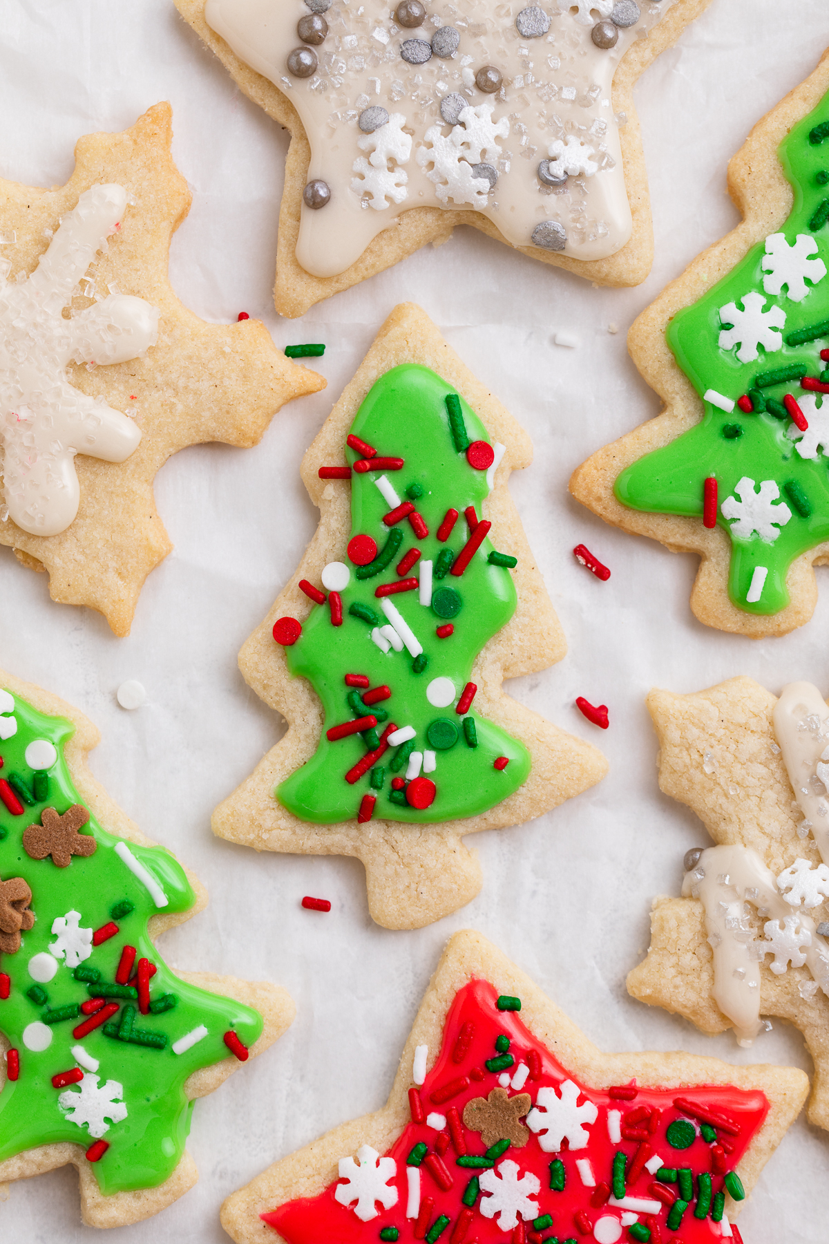Overhead view of decorated gluten-free Christmas cookies, with a green tree-shaped cookie front and center.