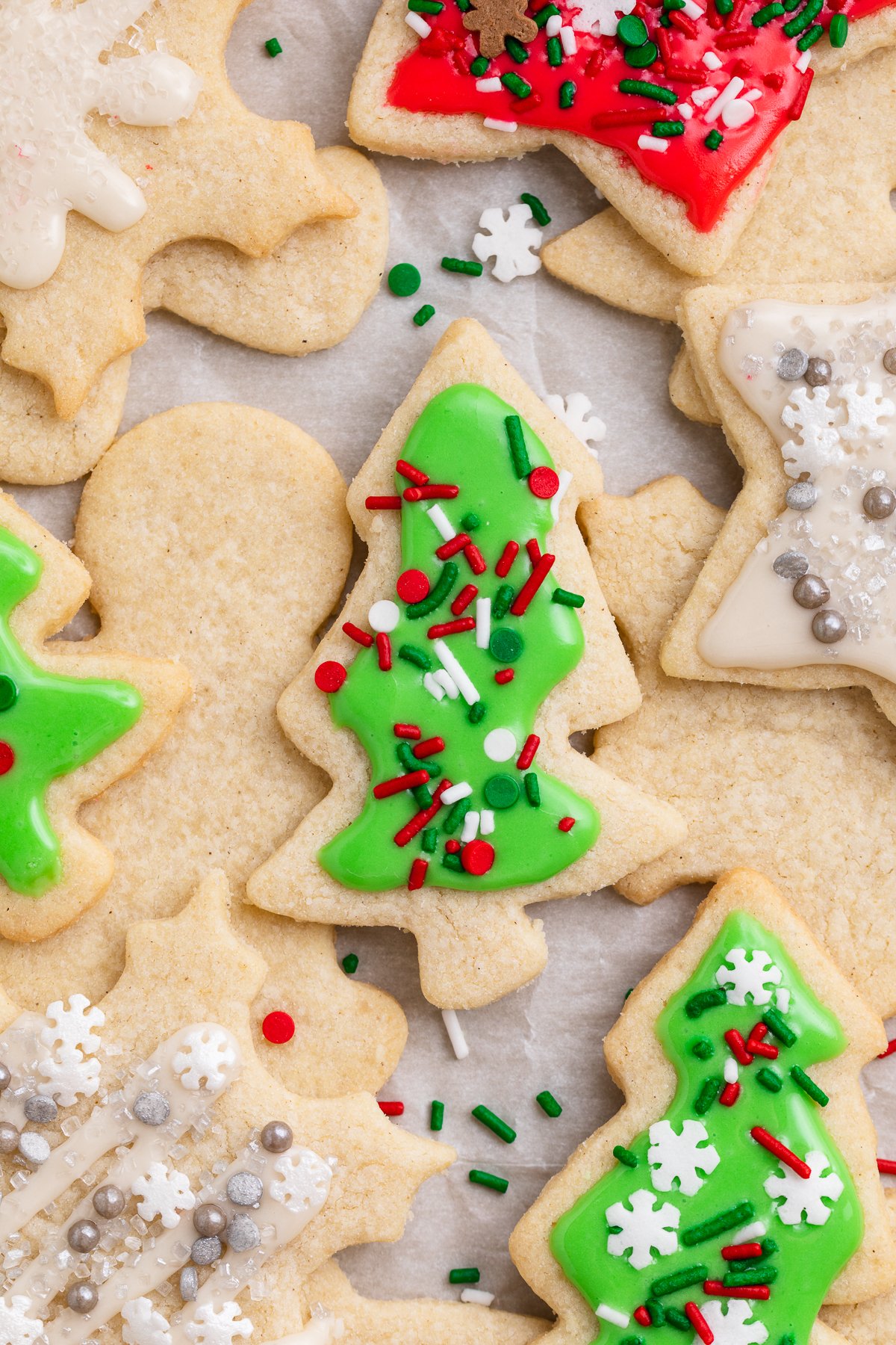 Overhead view of decorated gluten-free Christmas cookies, with a green tree-shaped cookie front and center.