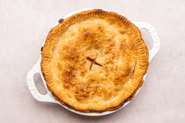 Overhead view of fully baked beef pot pie in a pie dish with two handles.