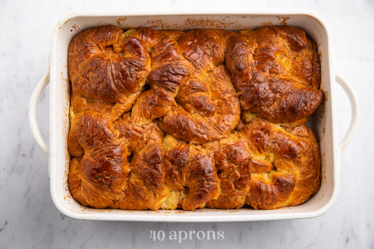 Overhead view of a baked croissant french toast casserole in a large rectangular casserole dish.