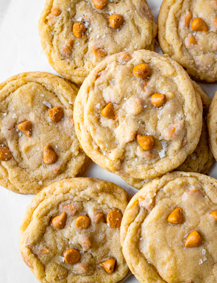Overhead view of a pile of chewy butterscotch cookies on a neutral background.