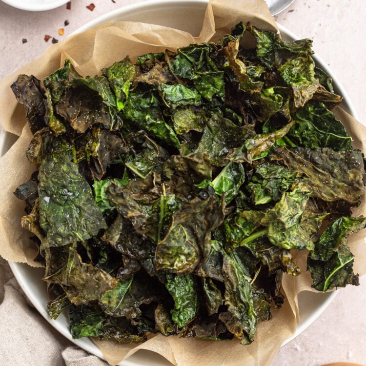 Overhead, zoomed out photo showing a top-down view of a large bowl of deep green air fryer kale chips.