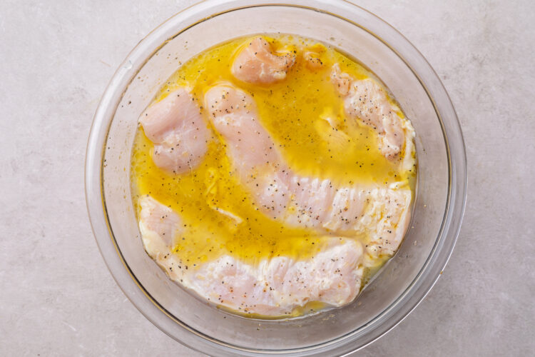 Chicken breasts in large glass mixing bowl of white wine marinade for chicken Bryan.