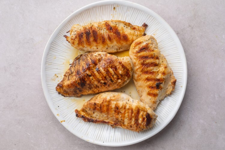 Grilled chicken resting on a plate.