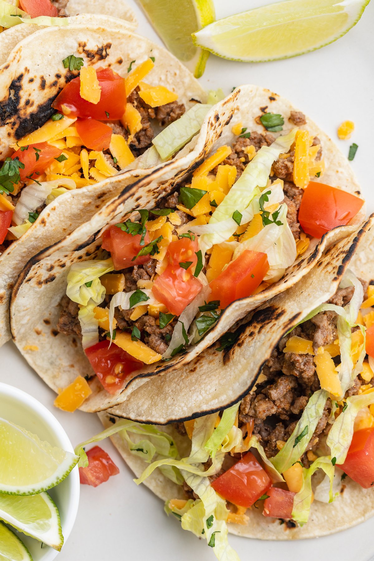 Close-up view of 3 keto tacos in homemade keto tortillas with lettuce and salsa.