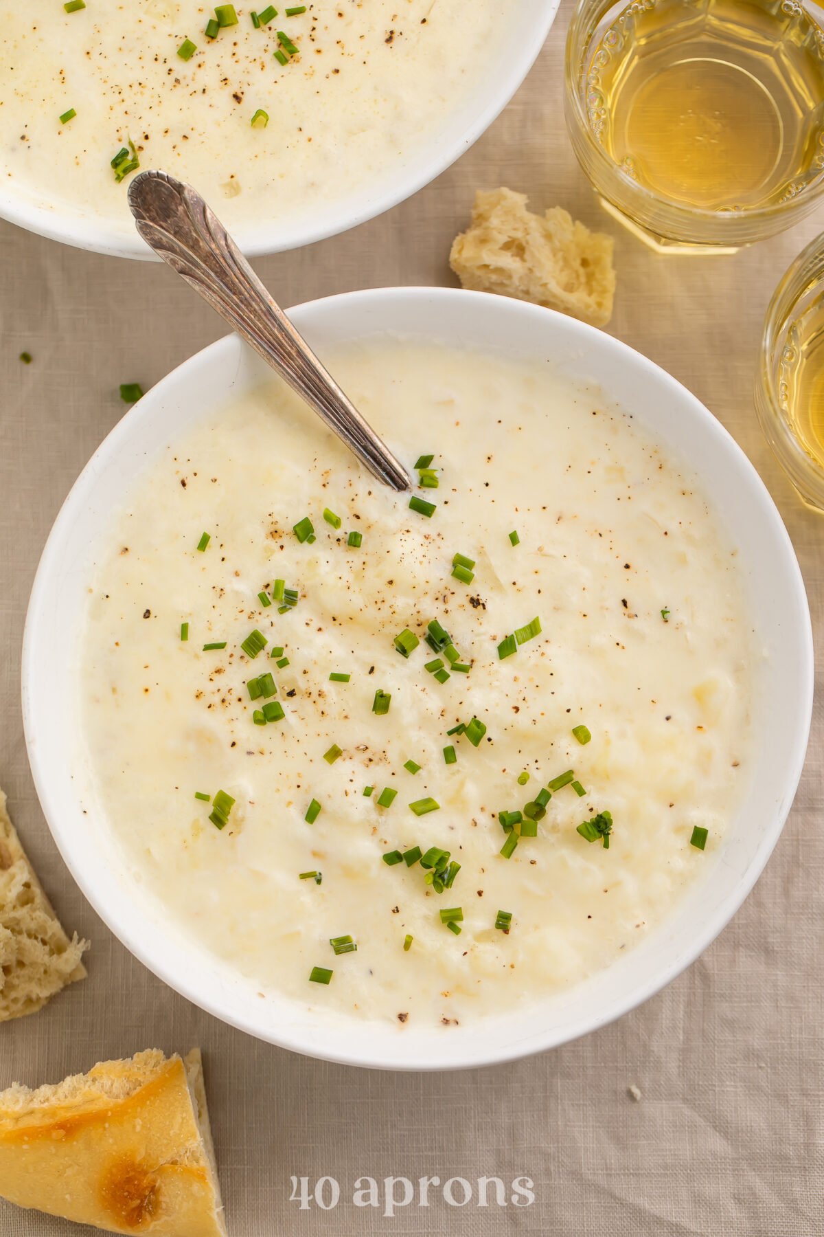Top-down view of a bowl of creamy old-fashioned potato soup topped with green onions.