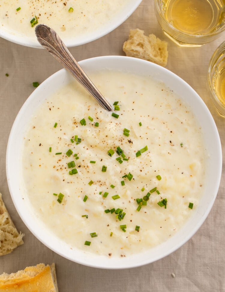 Top-down view of a bowl of creamy old-fashioned potato soup topped with green onions.