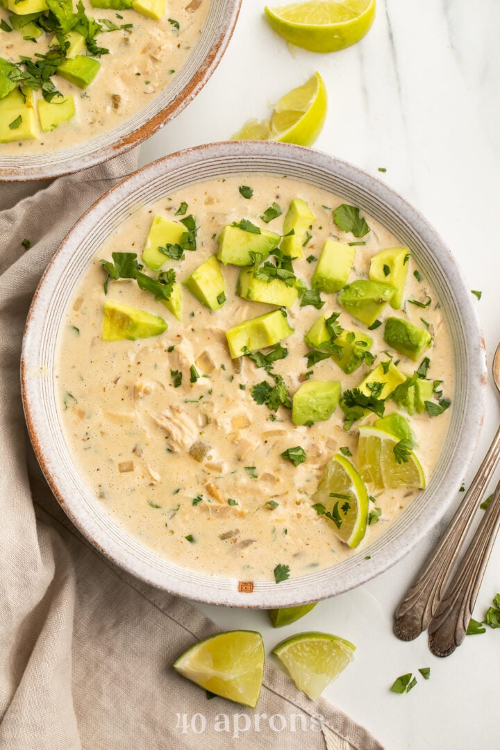 Top-down view of a bowl of Whole30-compliant white chicken chili topped with avocado and cilantro.