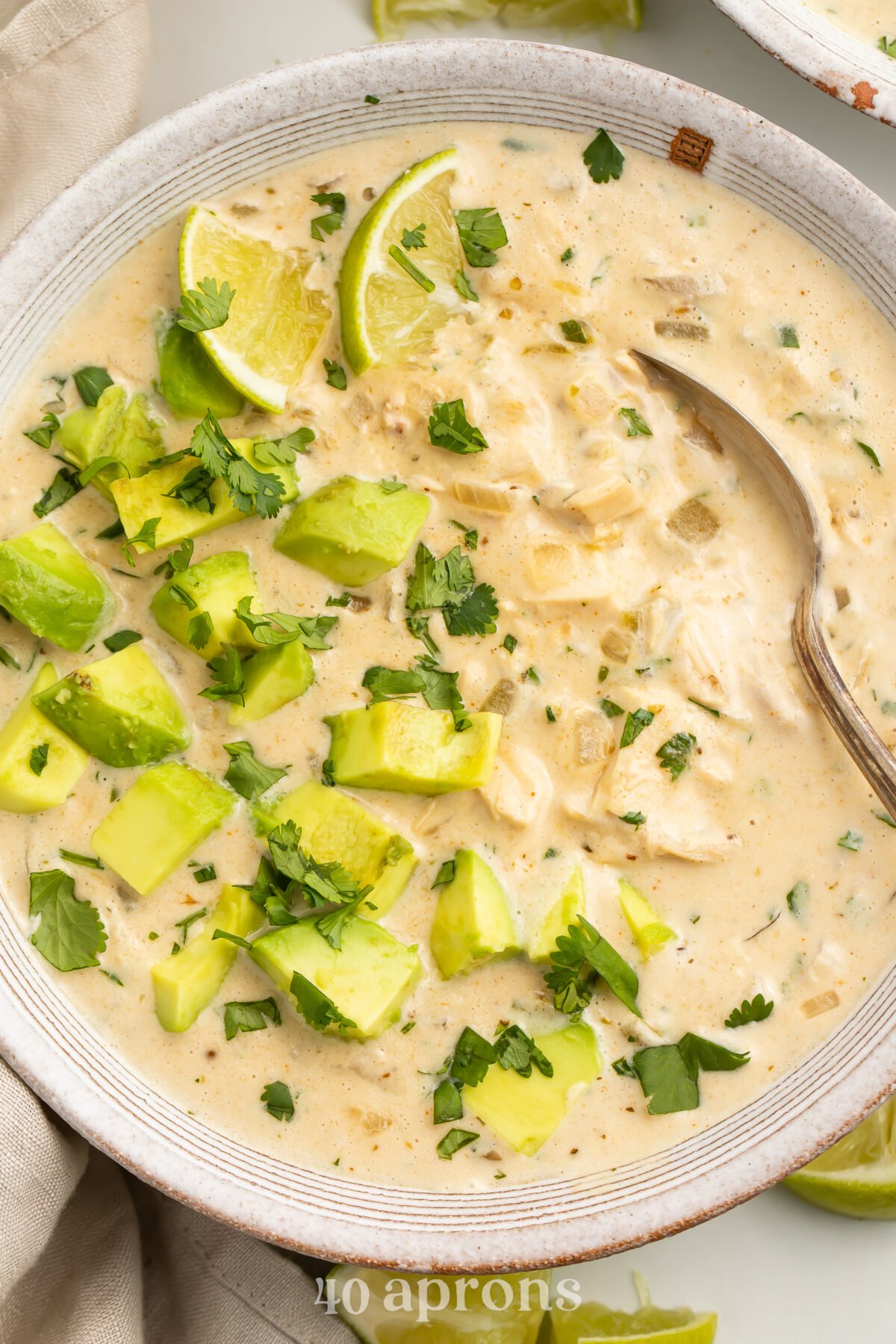 Zoomed in, top-down view of a bowl of Whole30 white chicken chili topped with avocado and cilantro.