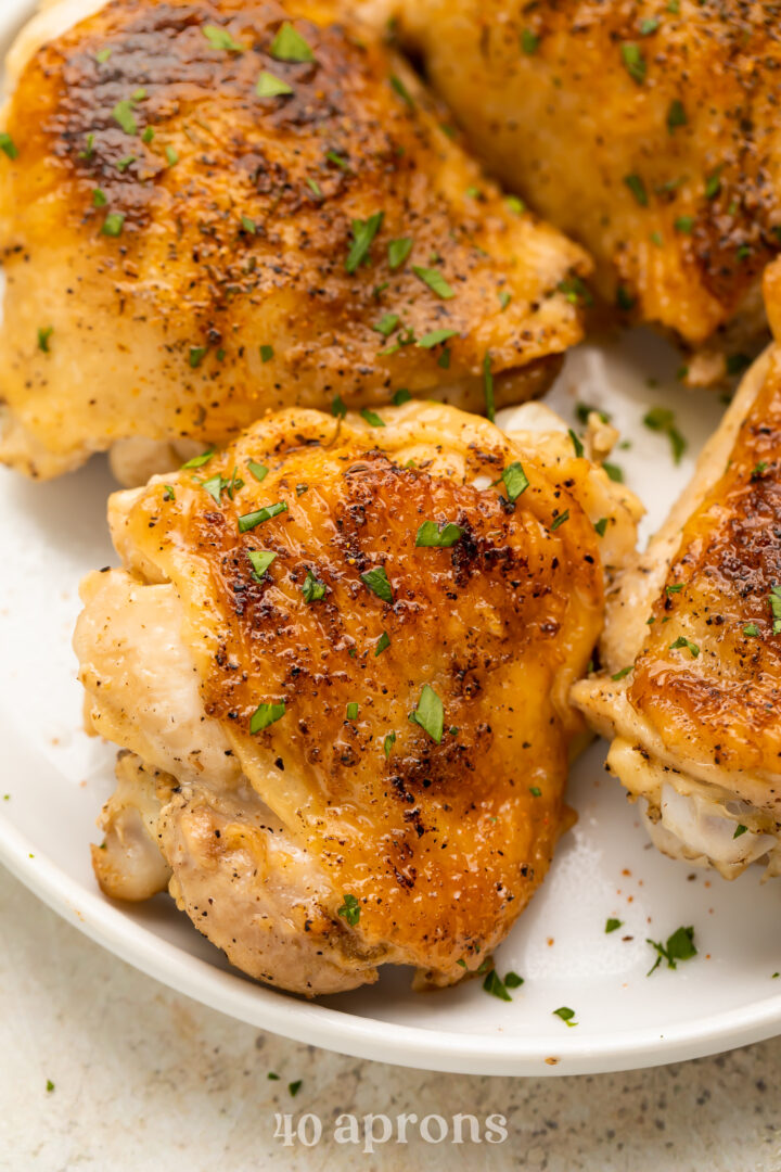 Overhead look at crispy, perfect Instant Pot chicken thighs on a plate.