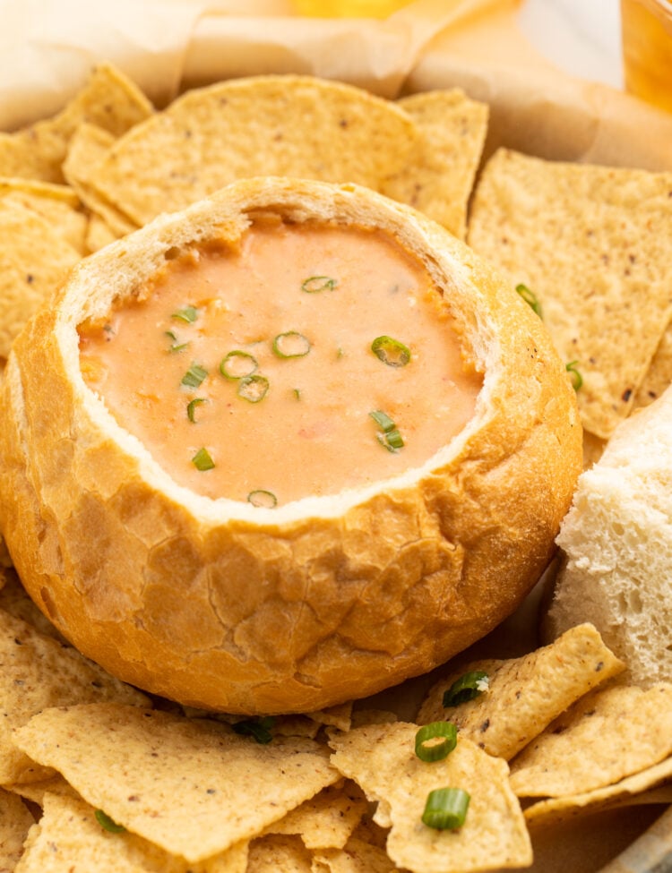 A bread bowl holding a copycat version of McAlister's chicken tortilla soup surrounded by tortilla chips.