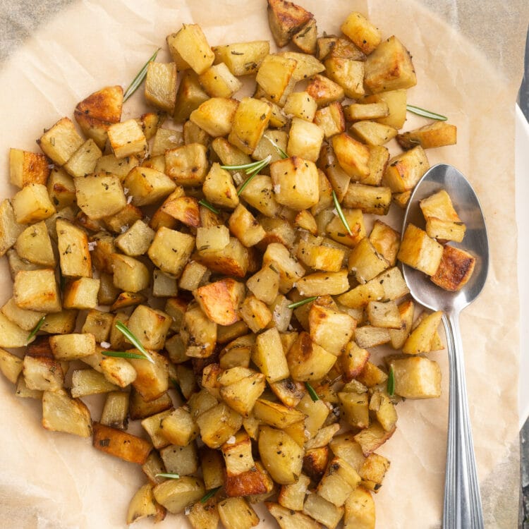 Overhead view of diced potatoes in a large bowl lined with parchment paper.
