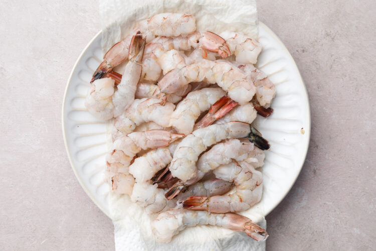 Large, peeled, deveined shrimp on a large plate.