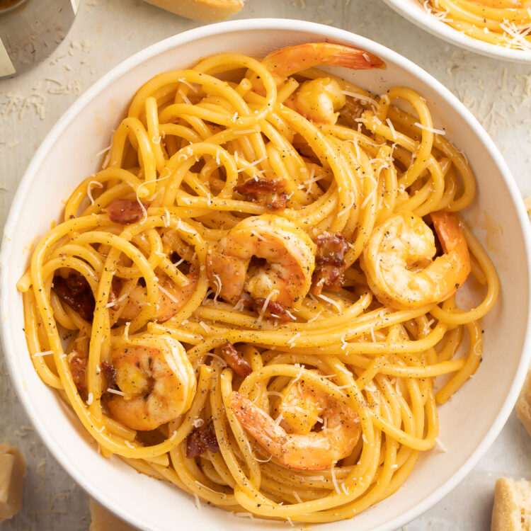 Top-down, overhead view of a large white pasta bowl filled with shrimp carbonara.