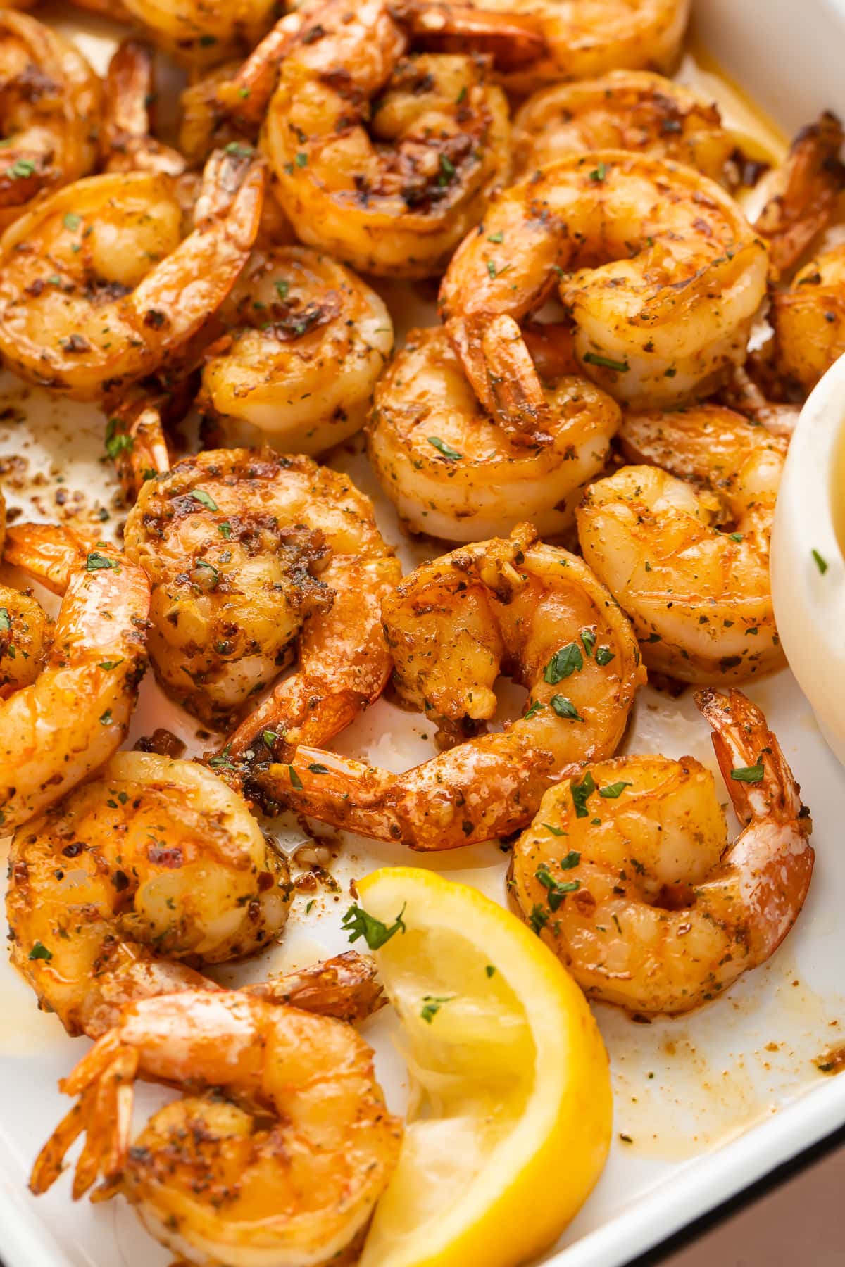 Close-up of garlicky broiled shrimp on a platter.