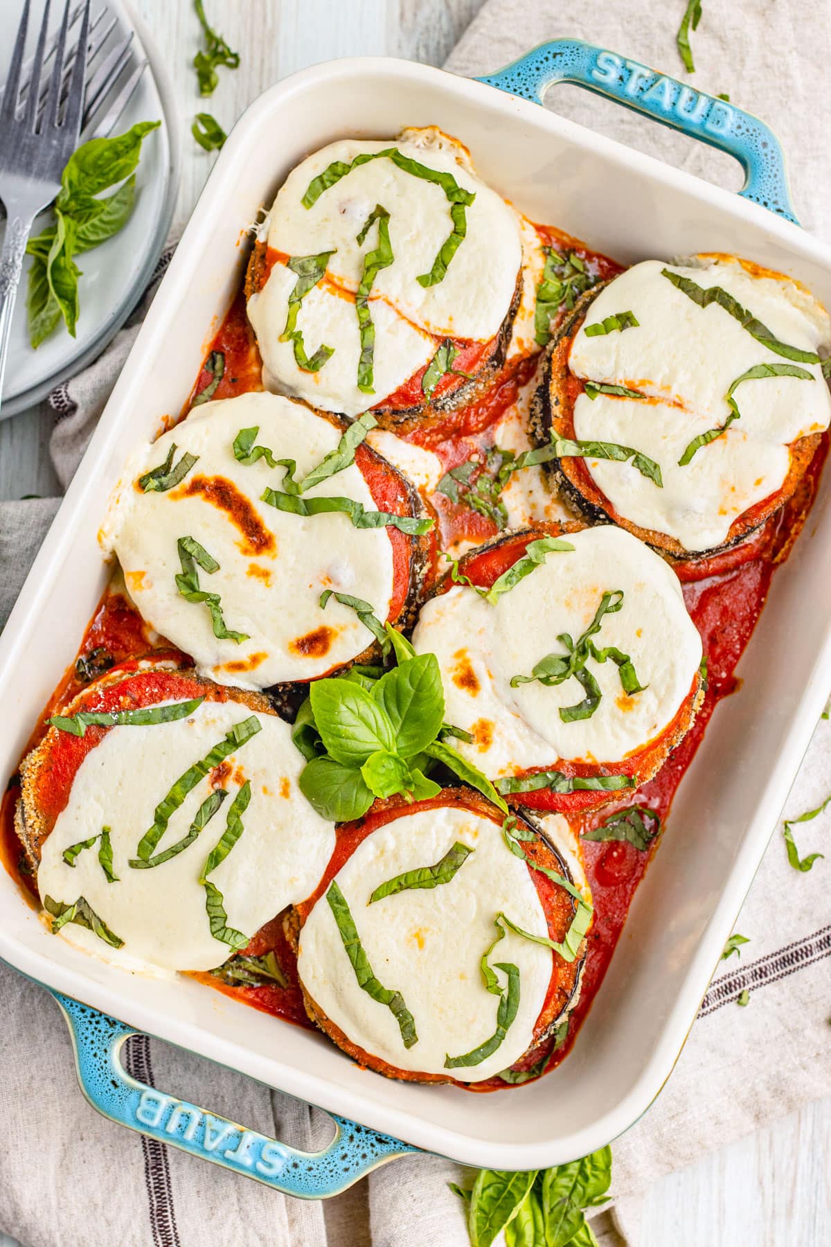 Keto eggplant parmesan in a deep baking dish with turquoise handles.