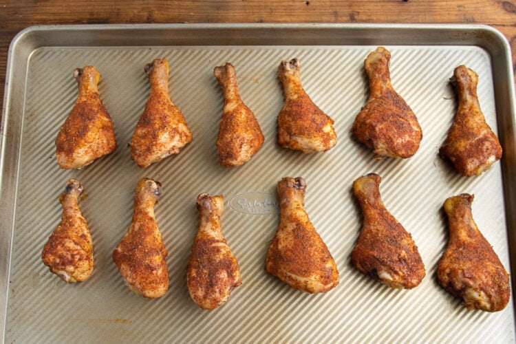 Smoked chicken legs on a baking sheet.