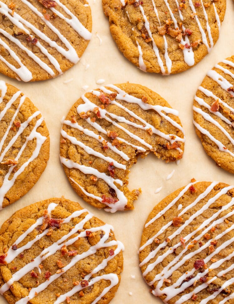 Bacon cookie butter cookies with a cinnamon glaze drizzle arranged on parchment paper.