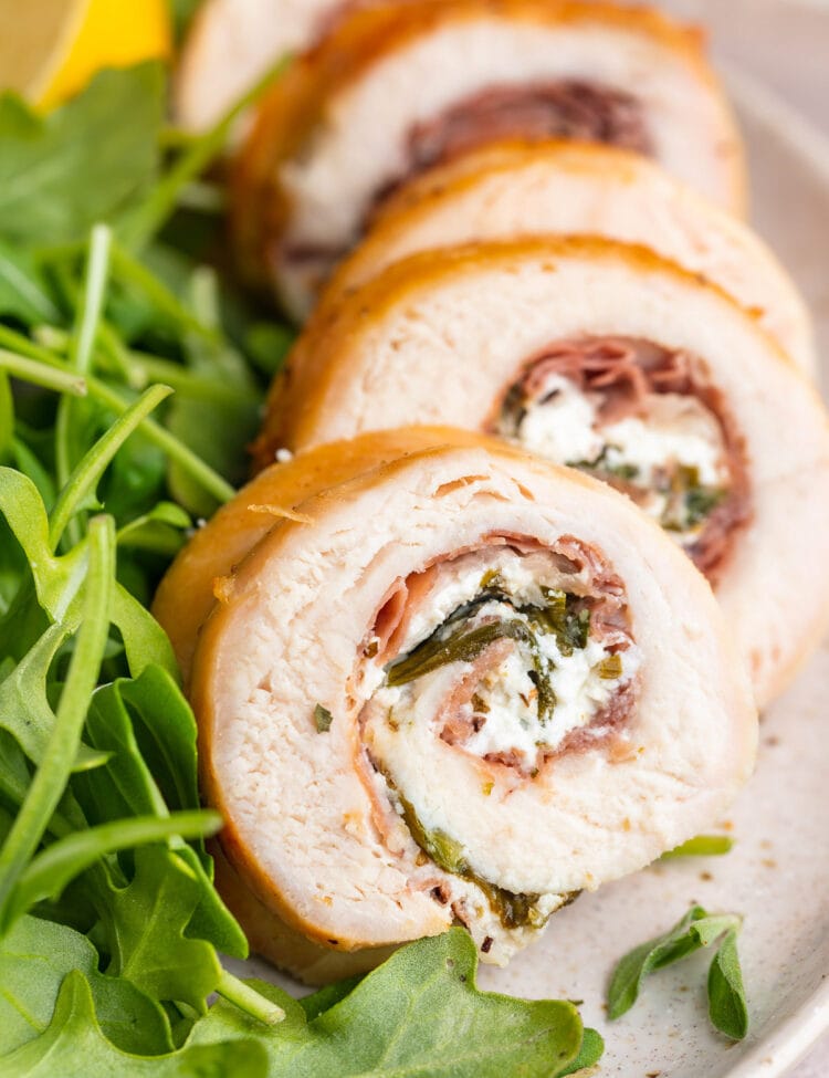 Chicken roulade sliced and plated with a small salad.