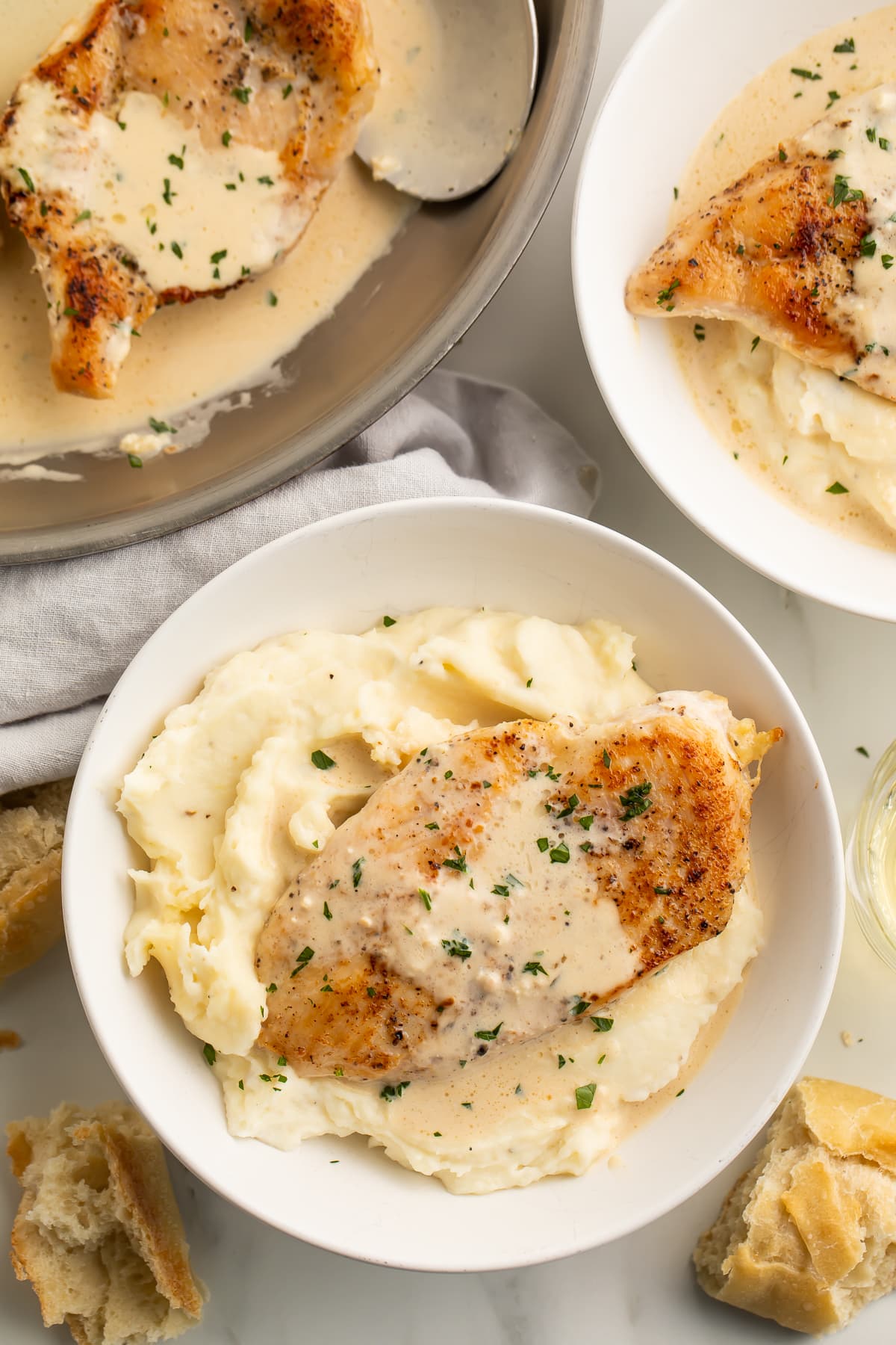 Cream cheese garlic chicken plated on a bed of rich mashed potatoes.