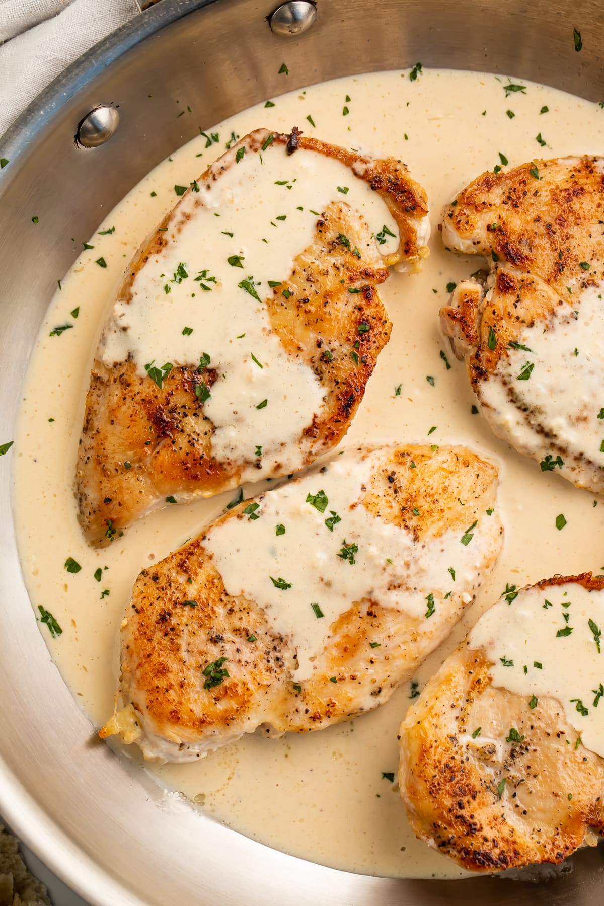 Cream cheese garlic chicken in a skillet with cream cheese sauce.