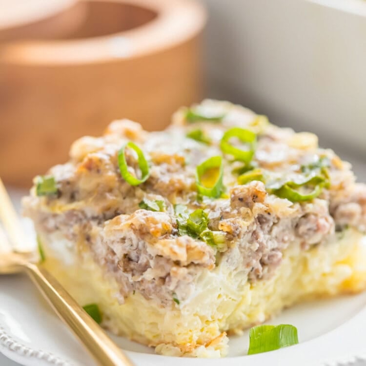A square of Whole30 hashbrown sausage casserole on a plate with a gold fork.