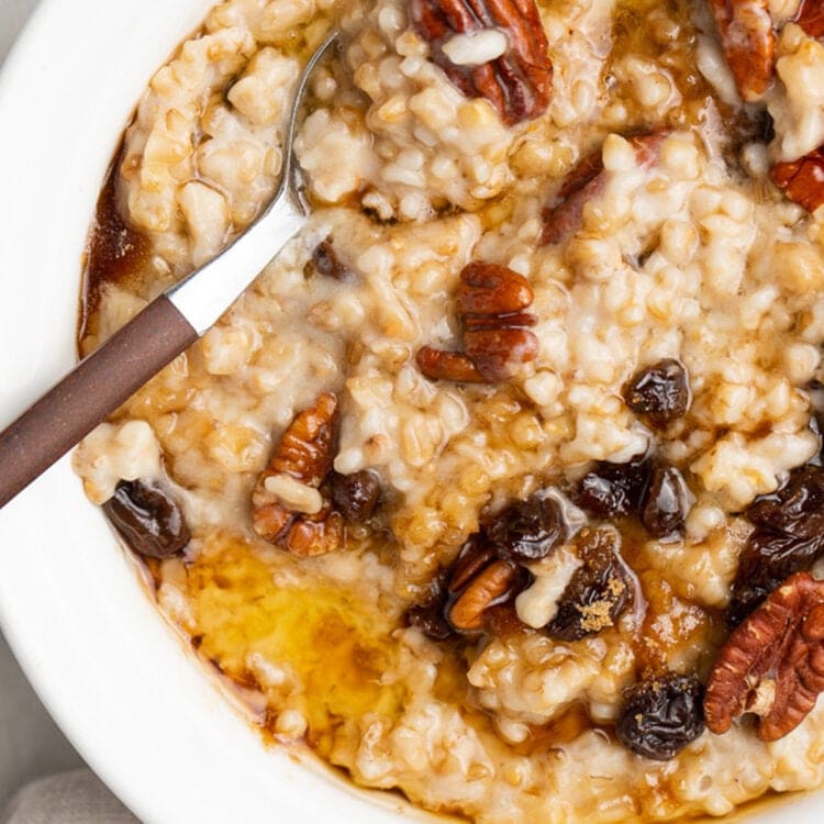 A bowl of Instant Pot steel cut oats topped with pecans and raisins.