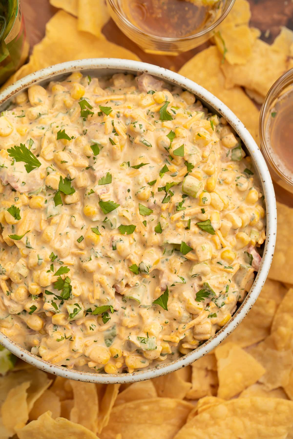 Top down view of a bowl of Mexican corn dip surrounded by tortilla chips.
