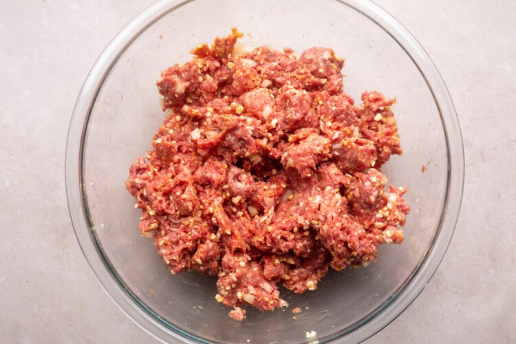 Ground beef mixture for gluten-free meatloaf in a large glass mixing bowl.