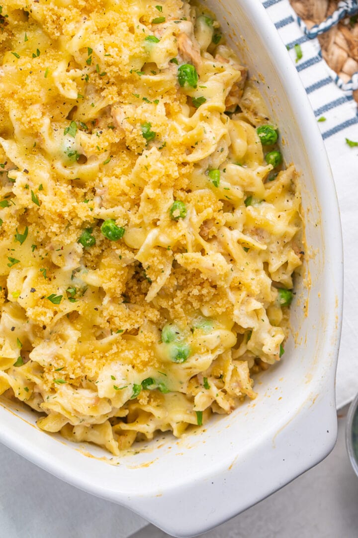 Overhead view of a casserole dish, angled from the top left corner of the image to the bottom right corner. The dish contains tuna noodle casserole.