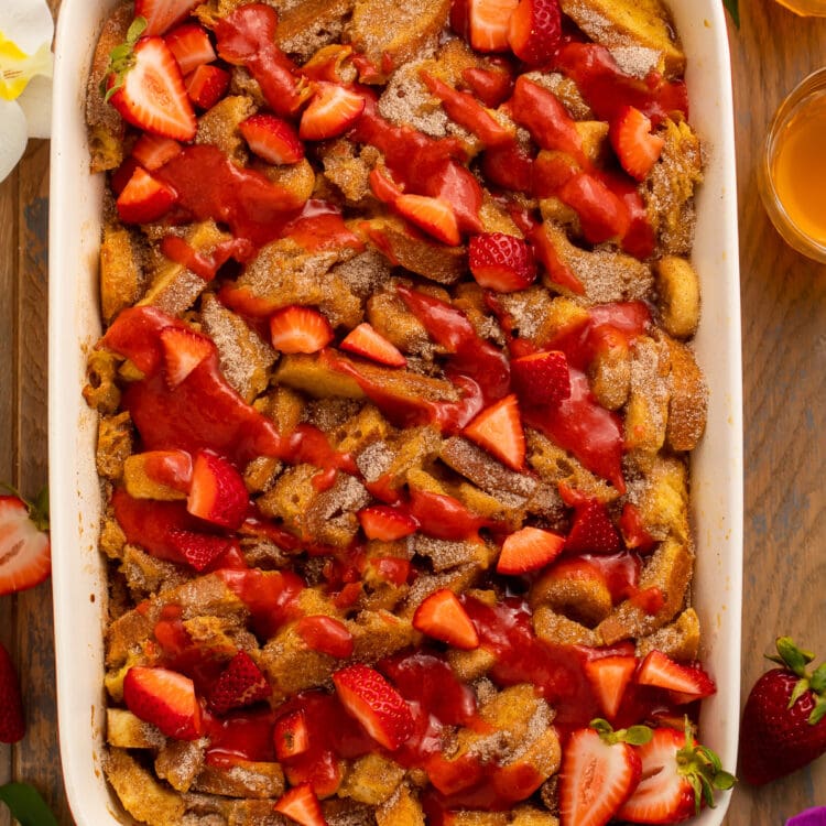 Overhead view of a large casserole dish filled with french toast, bananas, and strawberries.