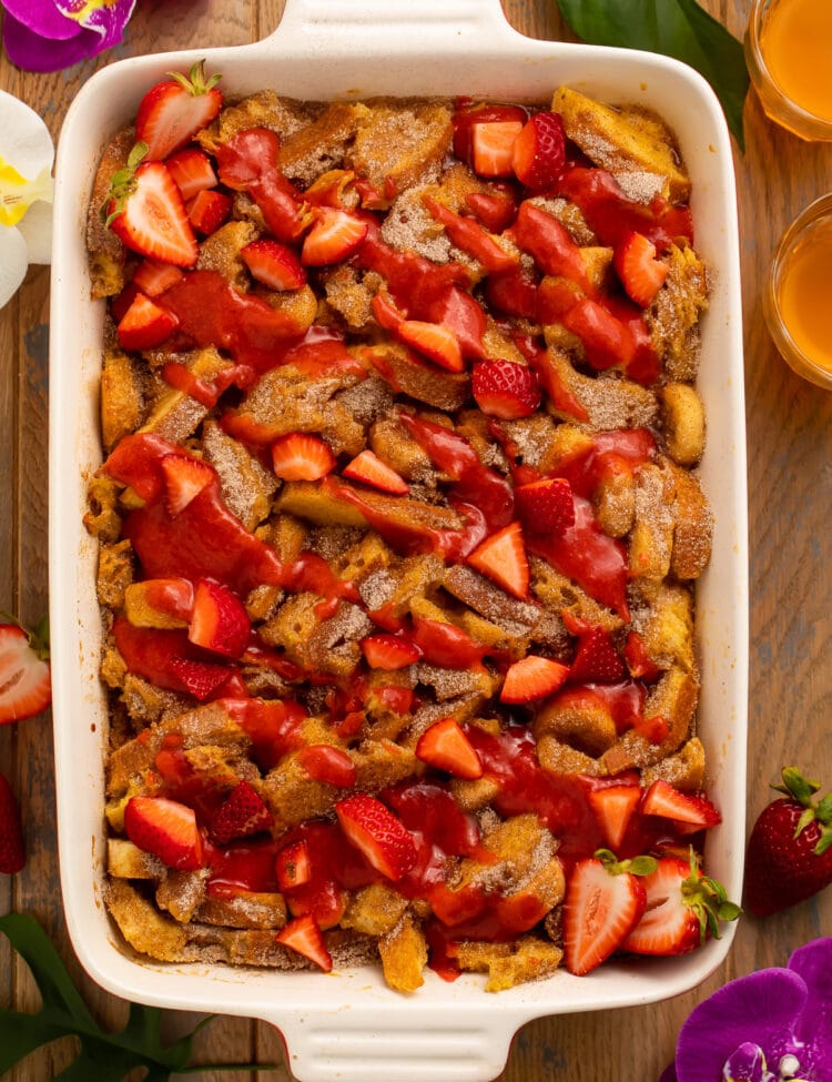 Overhead view of a large casserole dish filled with french toast, bananas, and strawberries.
