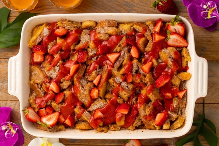 Fully prepared tonga toast casserole topped with strawberry sauce and fresh strawberries.