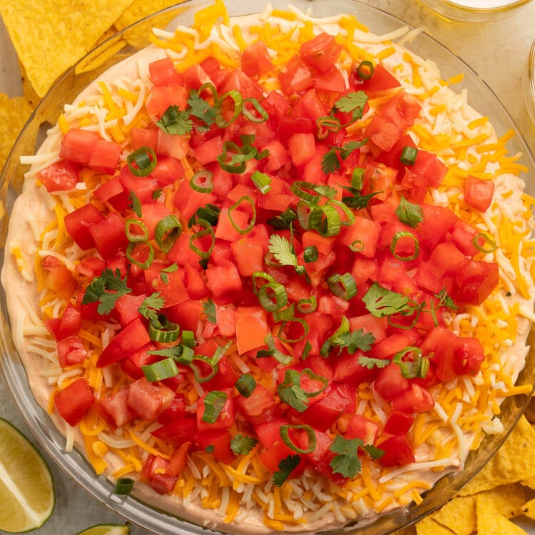 Top-down, overhead view of a 5 layer dip topped with gorgeous bright red tomatoes.