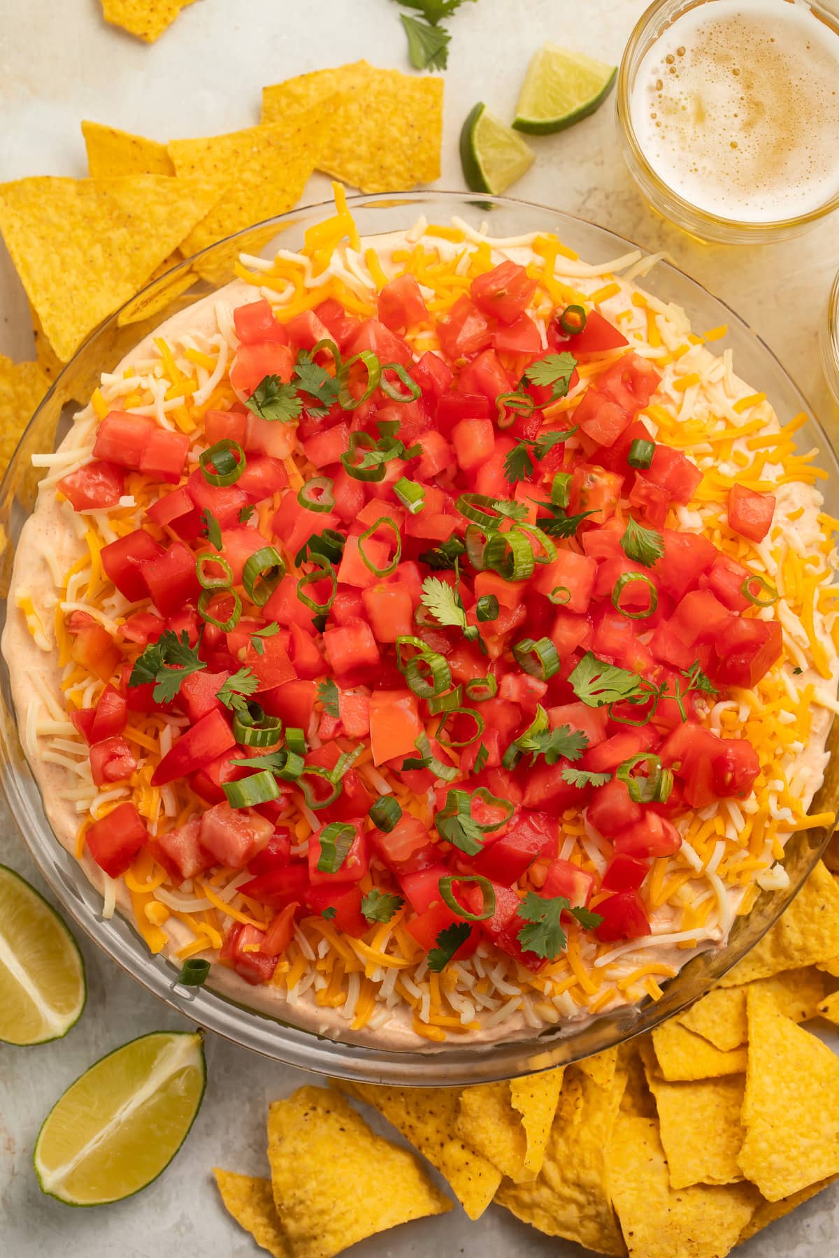 Top-down, overhead view of a 5 layer dip topped with gorgeous bright red tomatoes.