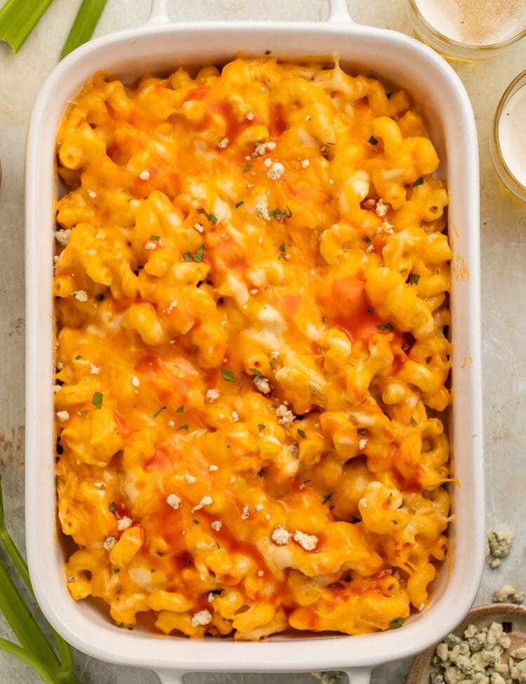 A large rectangular casserole dish filled with creamy, melty buffalo chicken mac and cheese topped with blue cheese crumbles.