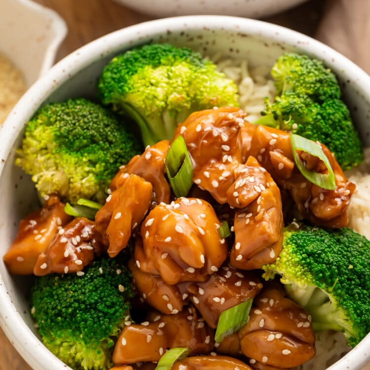 Angled side view of a bowl of Instant Pot chicken teriyaki with steamed broccoli on a bed of white rice.