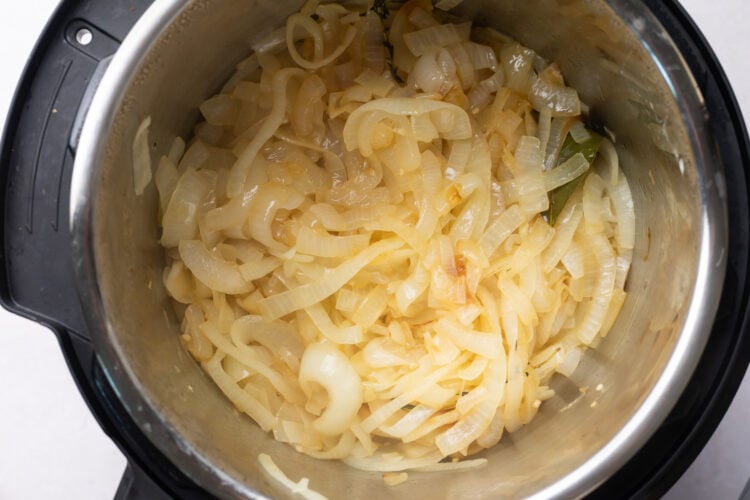 Sliced, softened onions simmered in red wine in the bottom of an Instant Pot.
