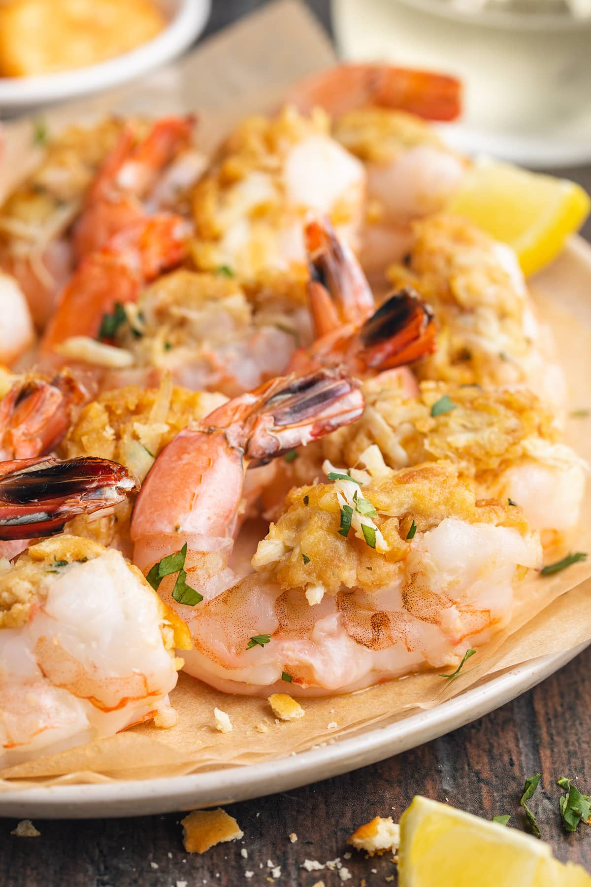 A plate of baked, stuffed shrimp with lemon wedges.